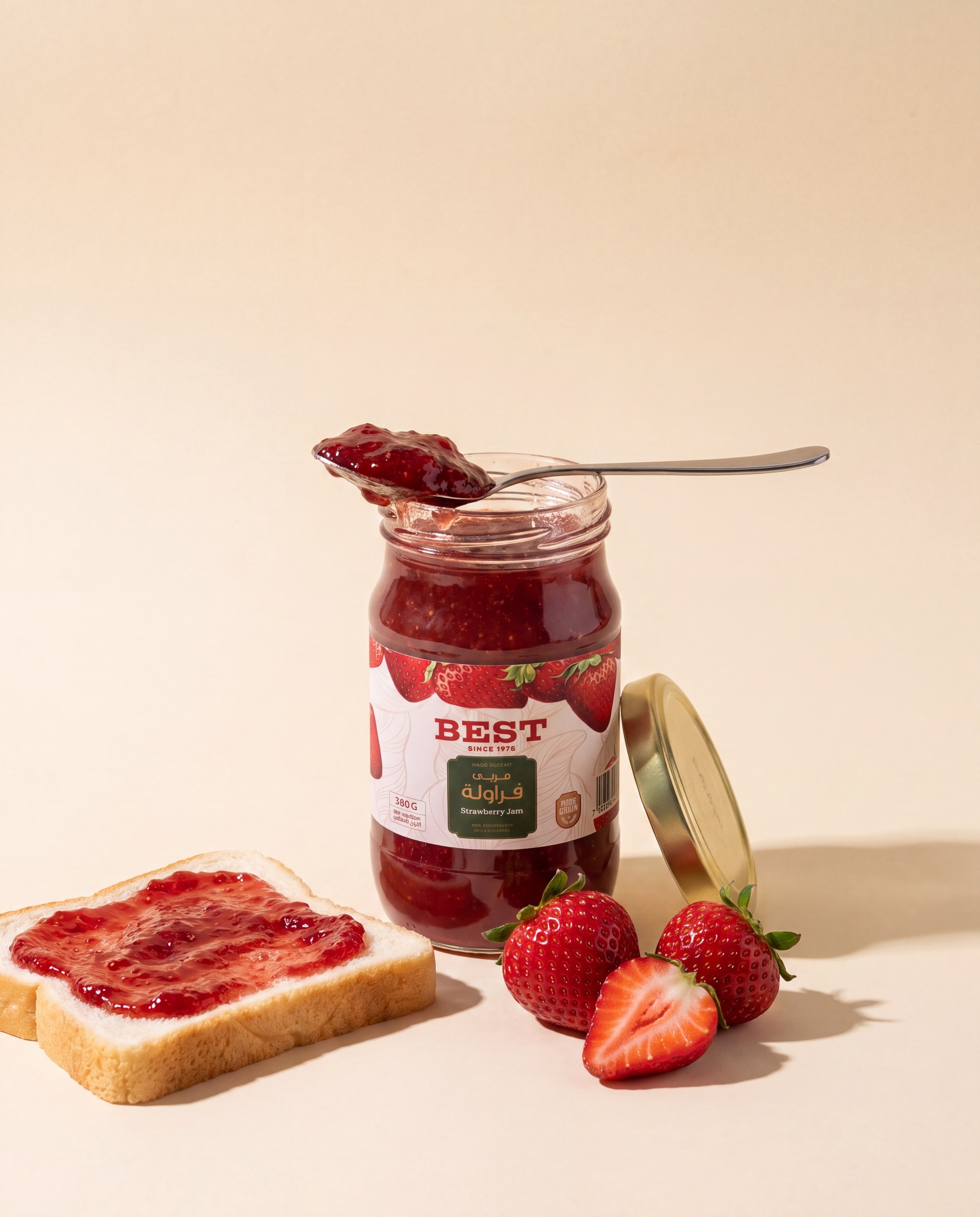 BEST strawberry jam, open jar with a loaded spoon